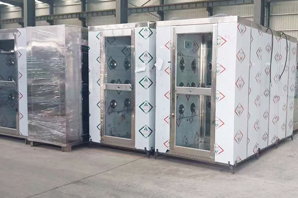 How does the air shower room ensure that the dust blown away will not contaminate the clean area again through its efficient filtration system?